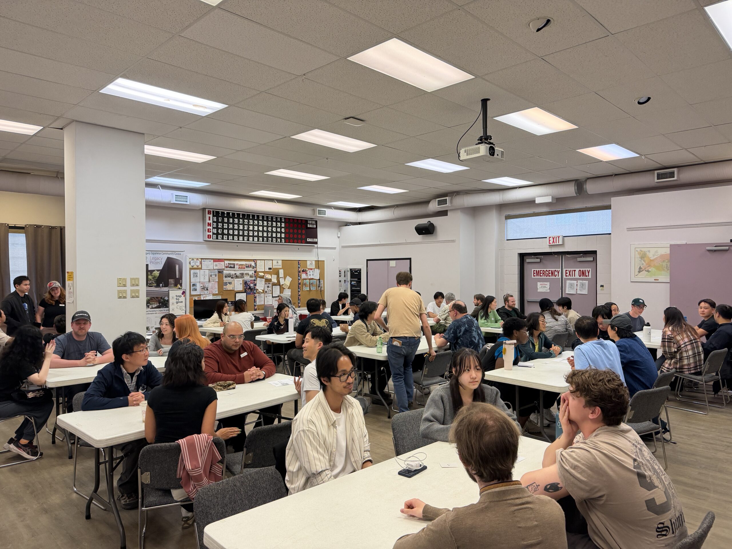 日系会館のホールで開かれたJapanglishの様子。大勢の参加者がテーブルごとに会話している